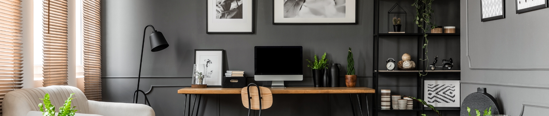Home office with dark gray wall and wood desk